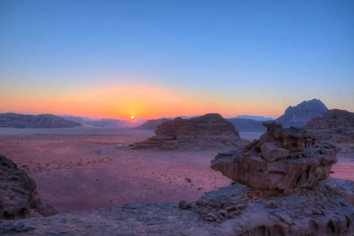 uitzicht over zandvlakte bij zonsondergang jordanie